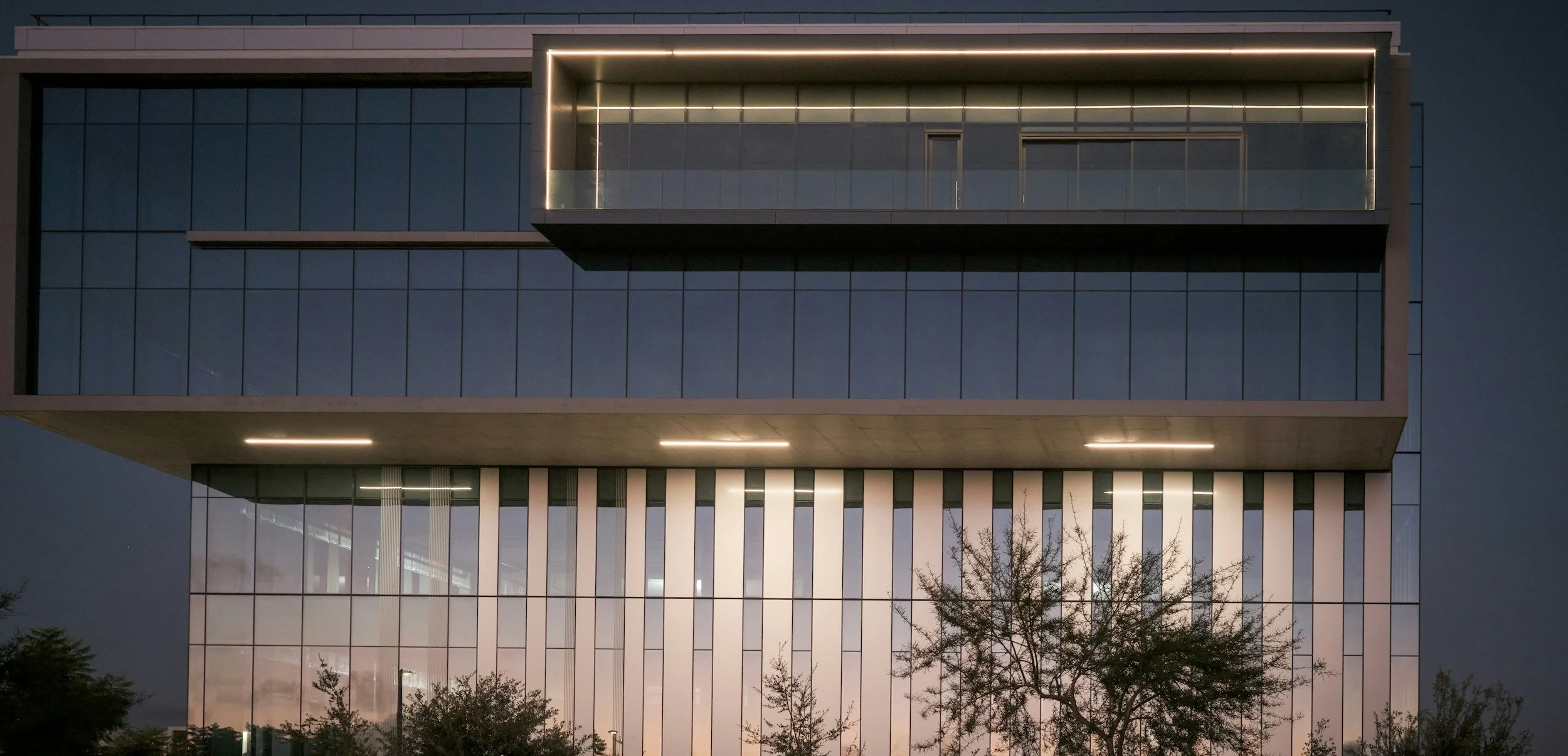 Modern commercial office building exterior with glass facade and vertical architectural fins