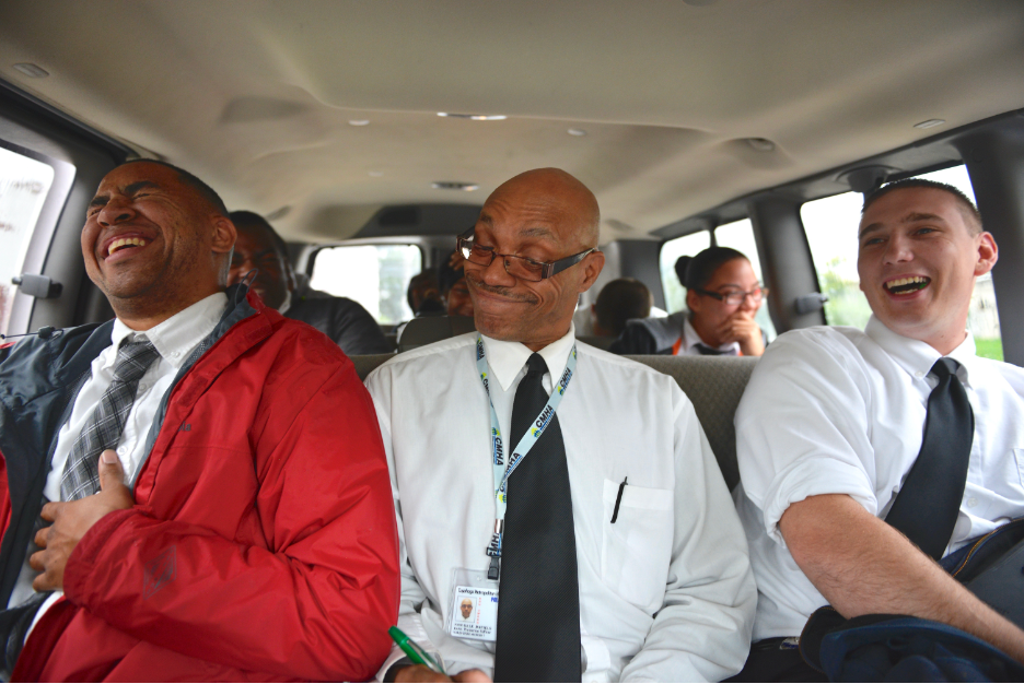 Group of diverse business professionals on a bus, laughing and enjoying themselves.