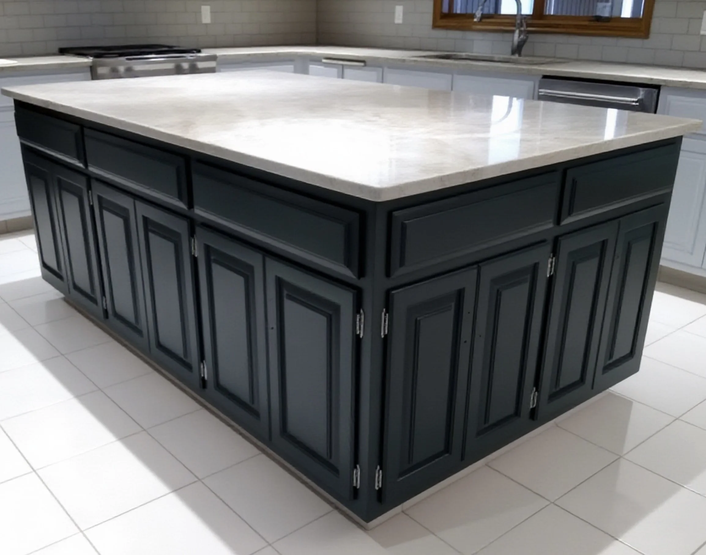 A custom-made kitchen island with a white marble countertop, flat black handpainted cabinets, and silver handles in a modern kitchen.