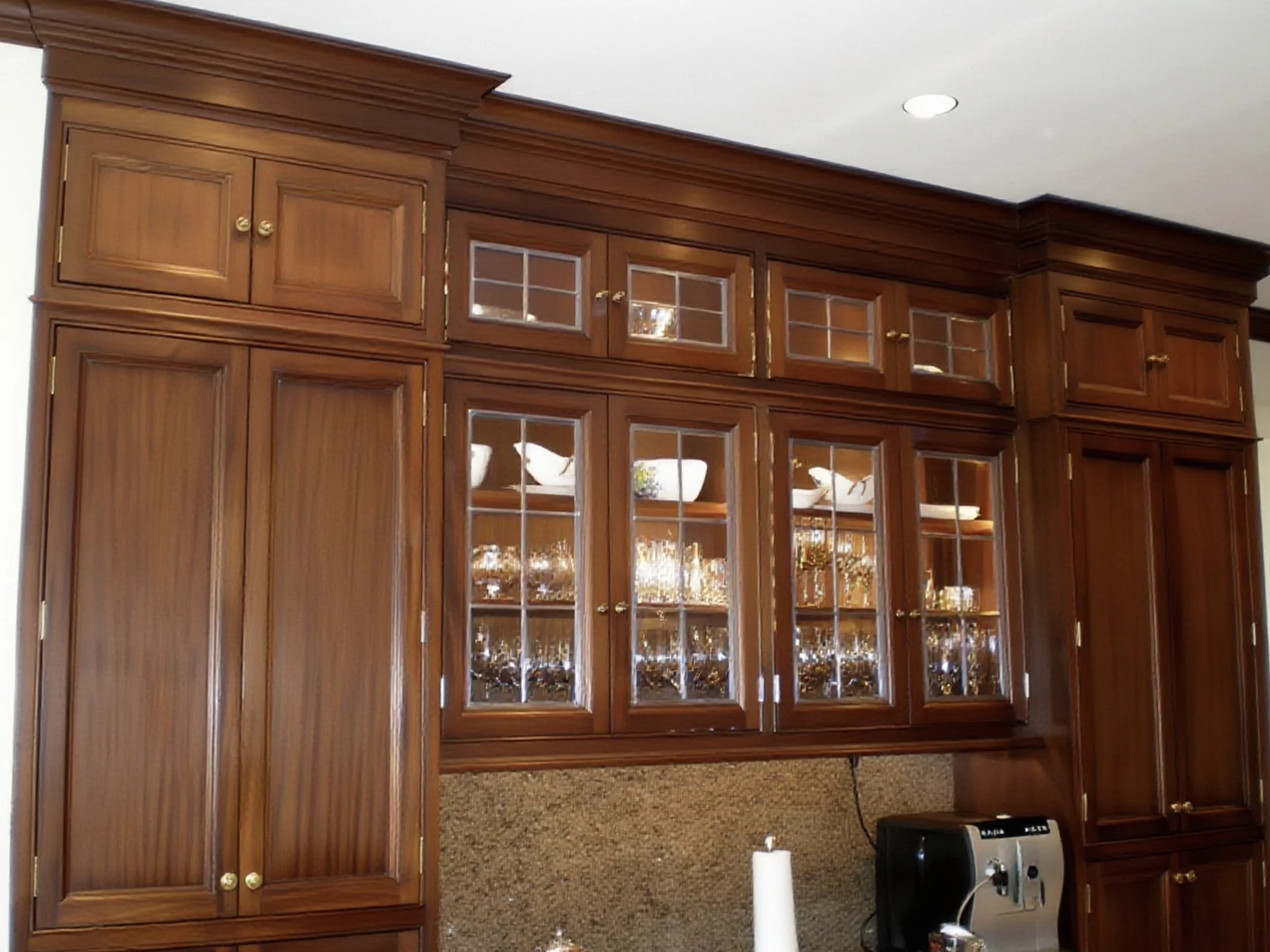 Handcrafted wooden display cabinet with glass doors, showing dishes inside, located in a room with a white ceiling.