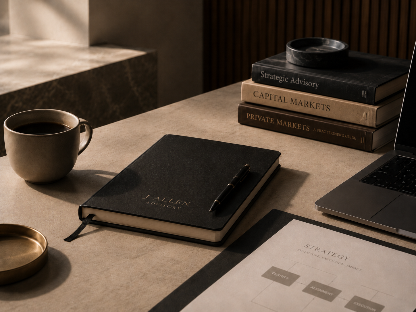 A workspace with a black coffee mug, a closed black advisory notebook with a pen, a stack of four books titled 'Strategic Advisory,' 'Capital Markets,' 'Private Markets,' and a black bowl on top of the books. A laptop and a document titled 'Strategy' are also visible.