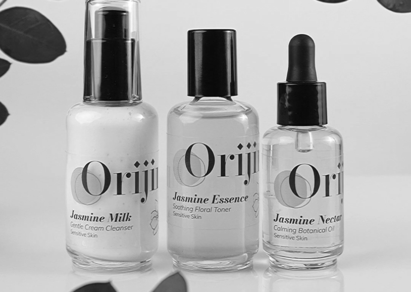 Three bottles of skincare products on a surface, including Jasmine Milk gentle cream cleanser, Jasmine Essence soothing floral toner, and Jasmine Nectar calming botanical oil for sensitive skin.