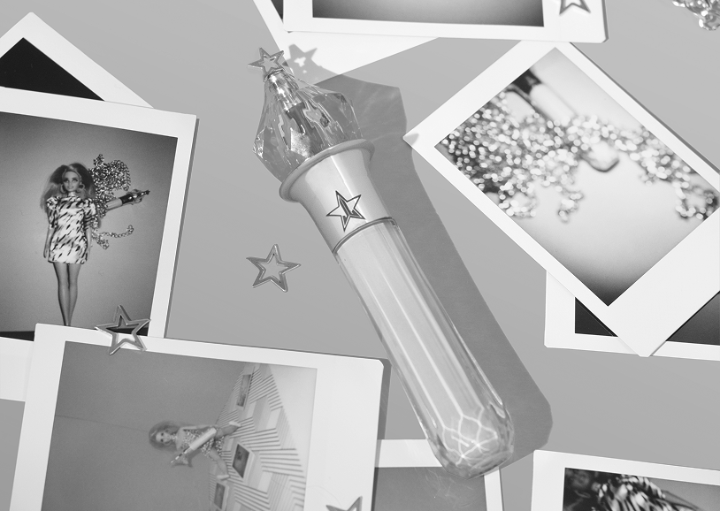 Black and white photo collection featuring a toy light stick with star designs, scattered photographs of a woman in a dress, a girl sitting at a desk, and glittery decorations.