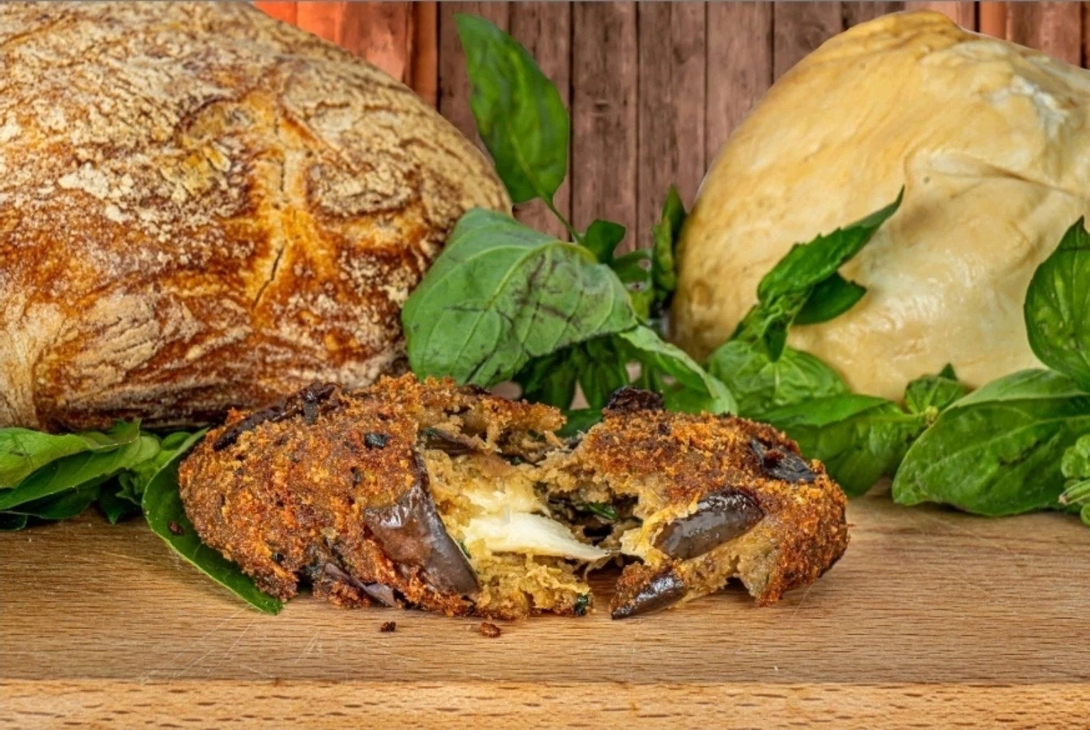 Peperone ripieno impanato, con una crosta dorata, con formaggio e cioccolato, accompagnato da pane e basilico fresco.
