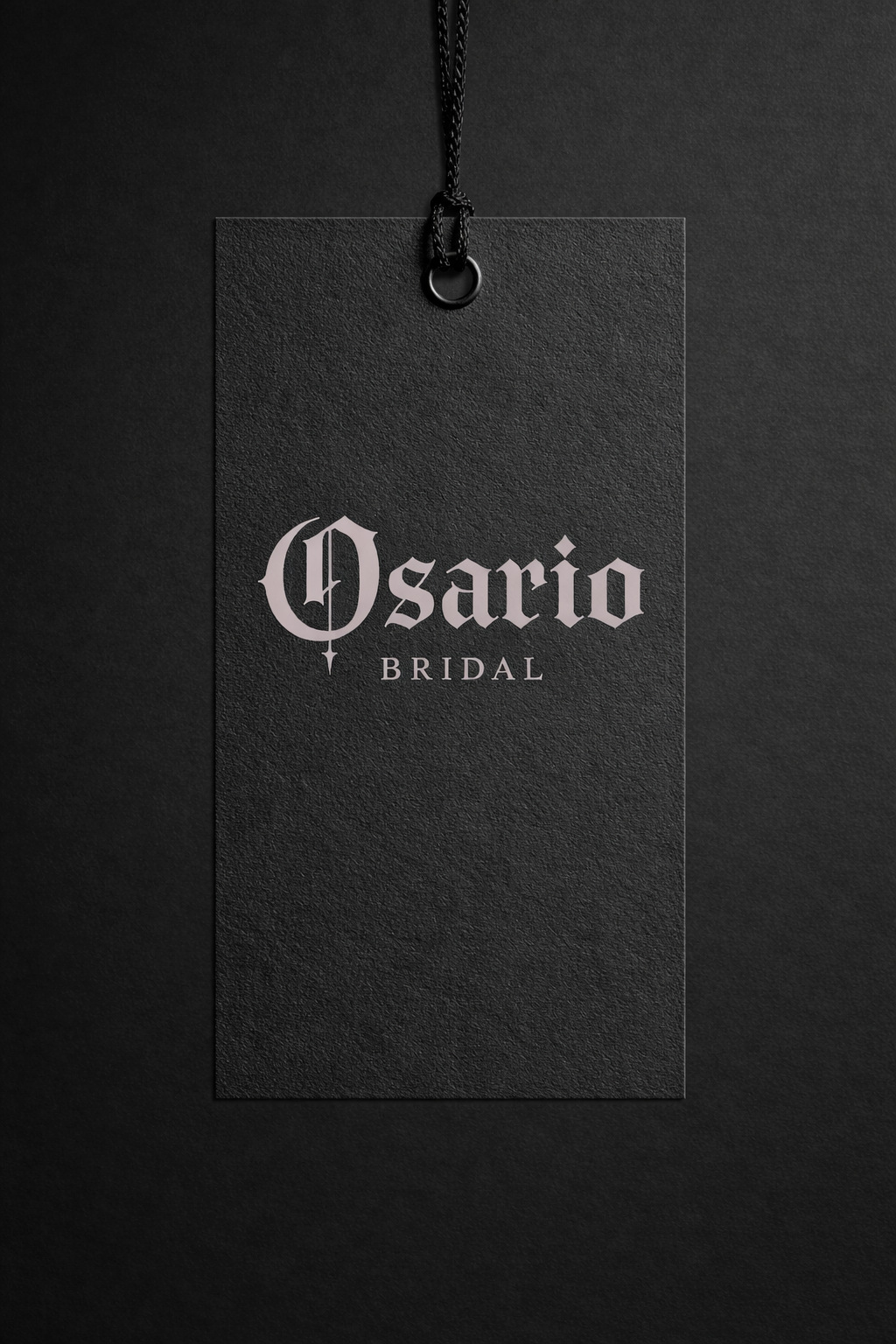 Black bridal tag from Osario Bridal with silver gothic-style text on a black textured background.