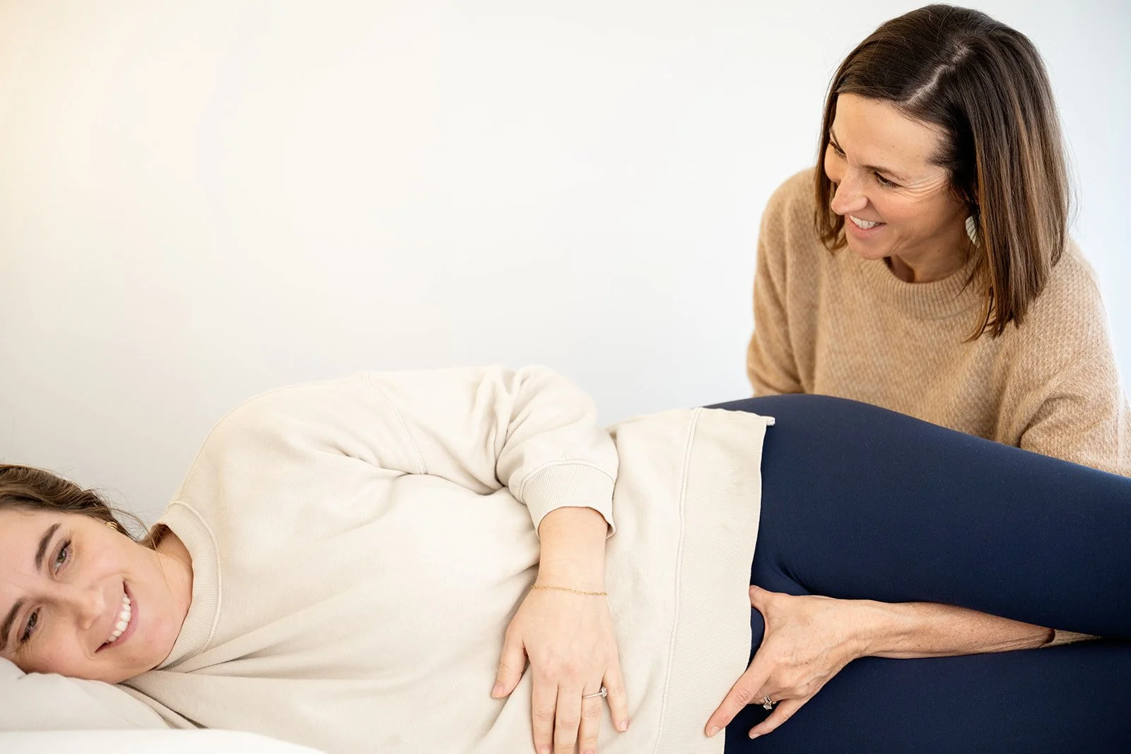 Pelvic health specialist performing visceral manipulation treatment with a patient who has painful periods.