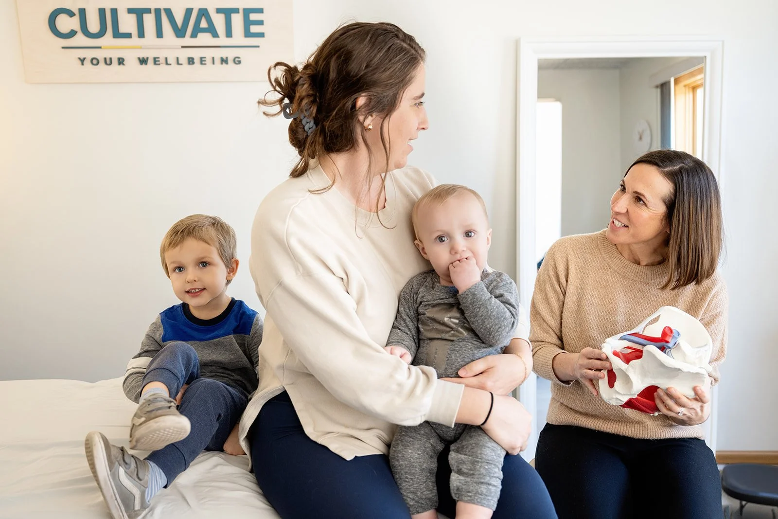 Postpartum patient with her children meeting with a pelvic health physical therapist at Cultivate Your Wellbeing, serving Mequon and Brookfield, Wisconsin.