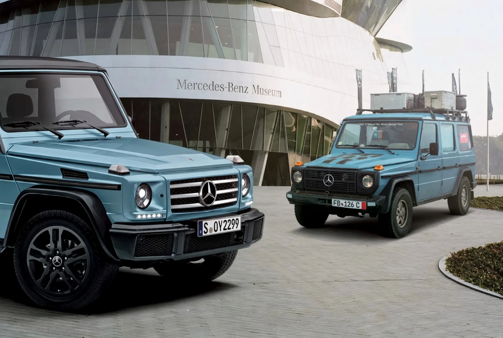 Two vintage Mercedes-Benz G-Class SUVs parked outside the Mercedes-Benz Museum. The vehicles are both painted in a similar shade of blue.