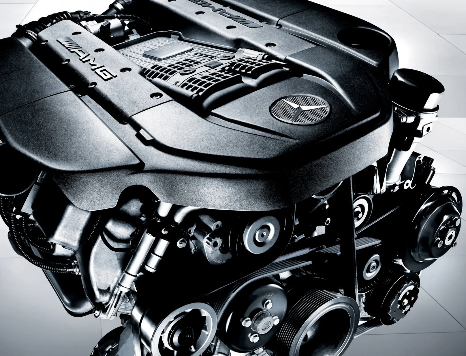 Close-up of a Mercedes-AMG automotive engine showing various mechanical parts and the Mercedes logo.