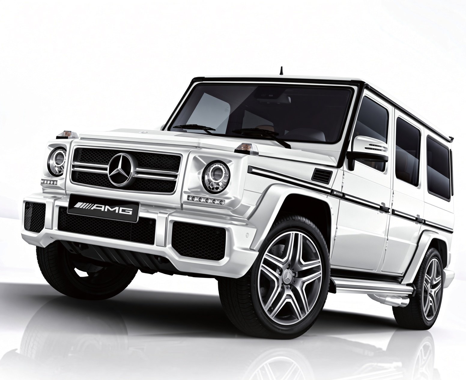 A white Mercedes-Benz G-Class SUV with AMG branding, featuring black accents, large alloy wheels, and a rugged design.
