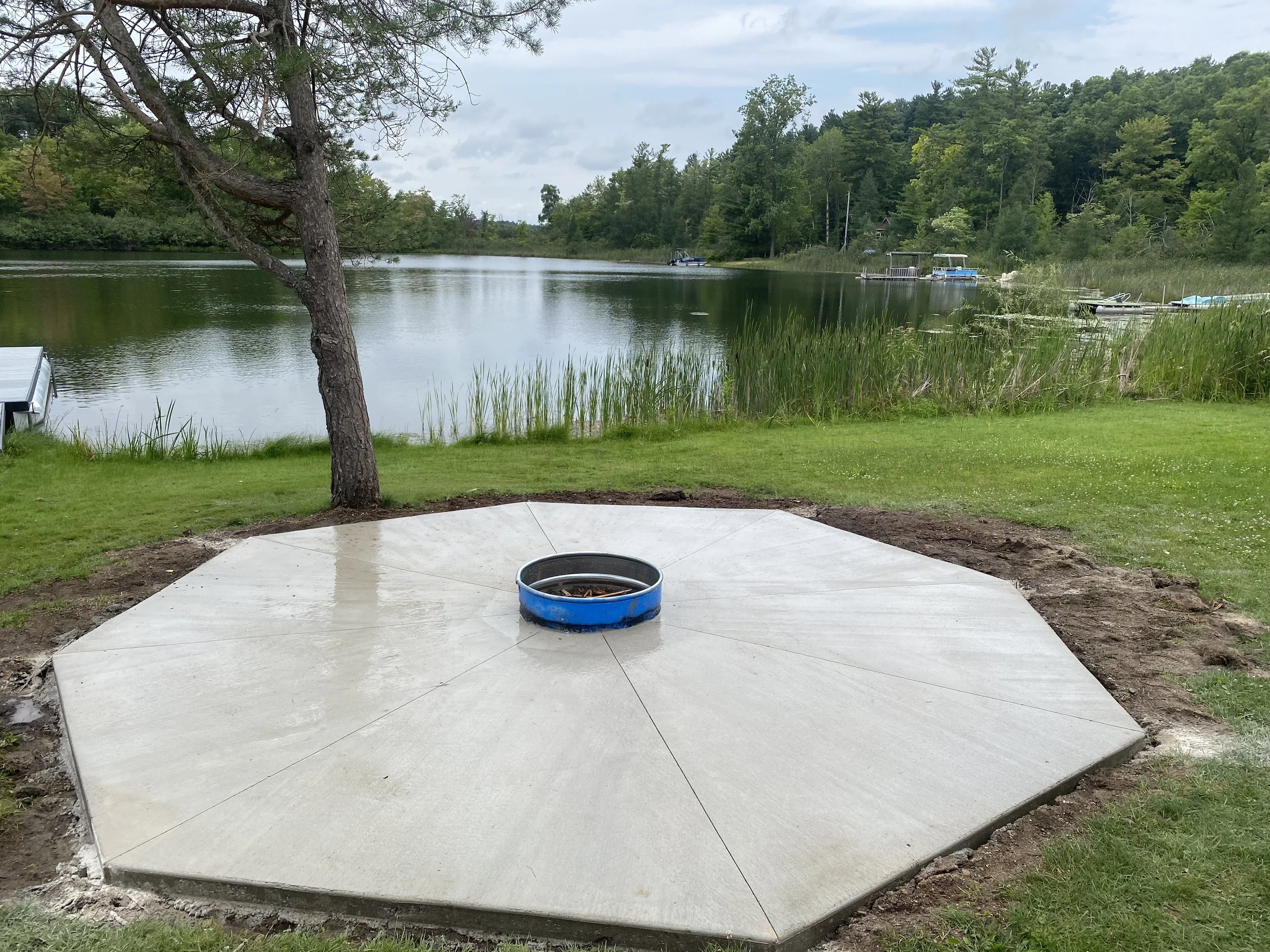 A concrete patio area with a built in fire-ring to ensure all times of the day are to be enjoyed by the lake.