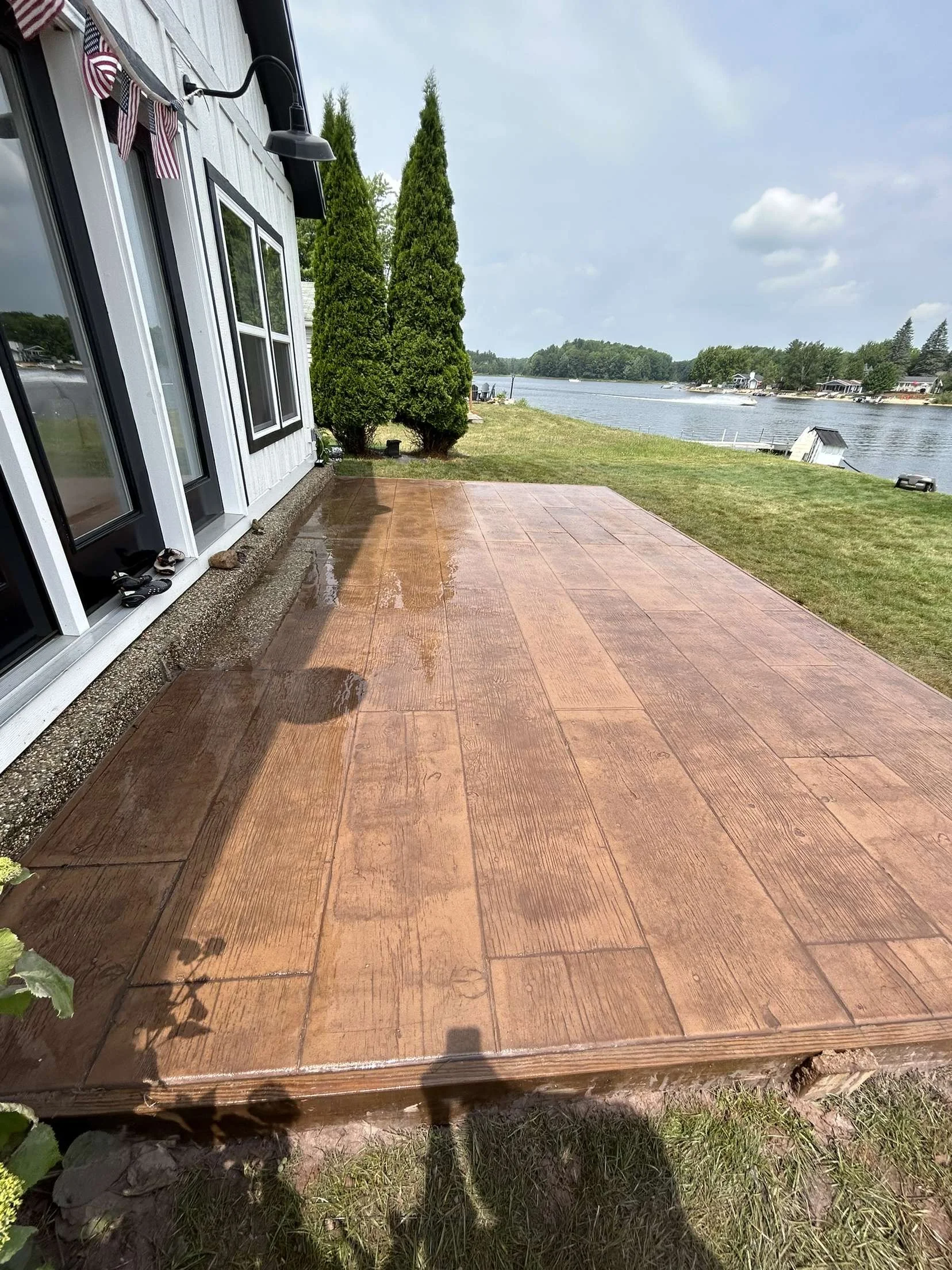 A backyard colored and stamped concrete patio to relax on while observing all the lake activities.
