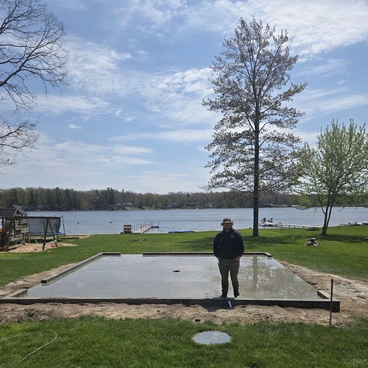 Isaiah standing proudly on a freshly poured garage slab for a happy customer.