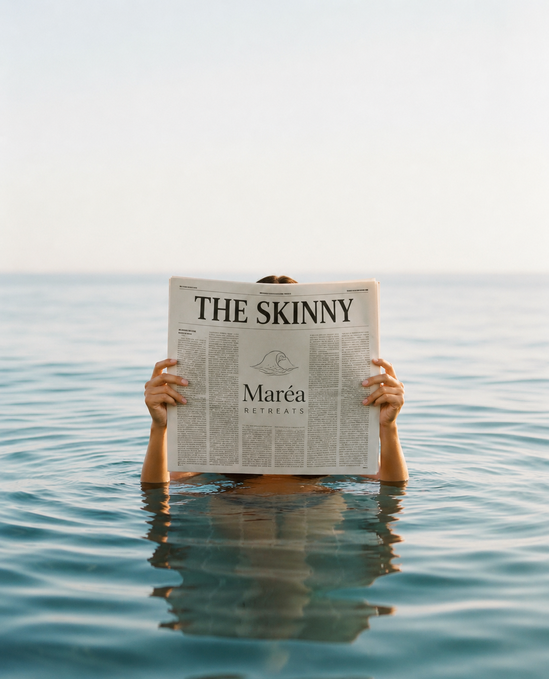 Person swimming in the ocean holding a newspaper titled 'The Skinny' with an ocean and clear sky in the background.
