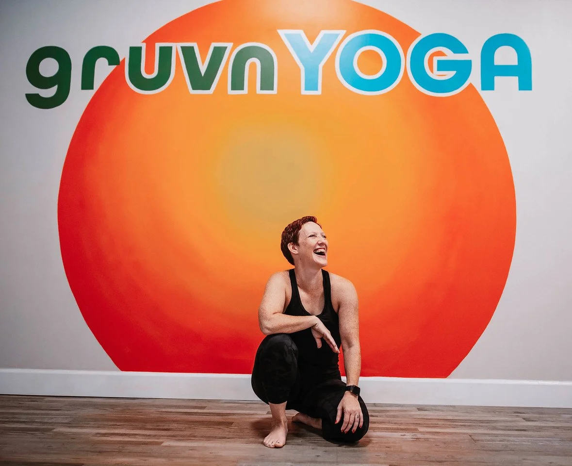 Kristyn McGeehan laughing at Gruvn Yoga Soul Center in East Cobb in front of the Gruvn Yoga mural