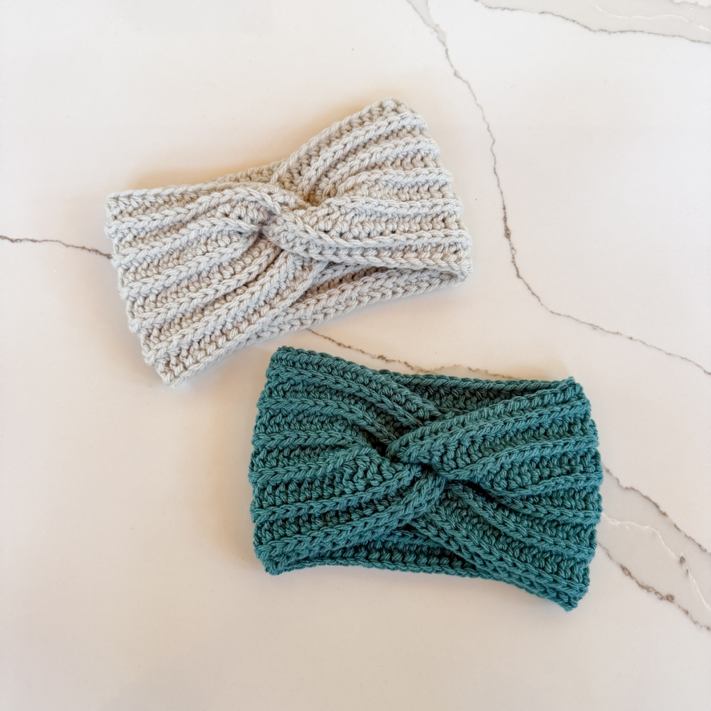 2-crochet-twist-headbands-laid-on-a-counter.webp
