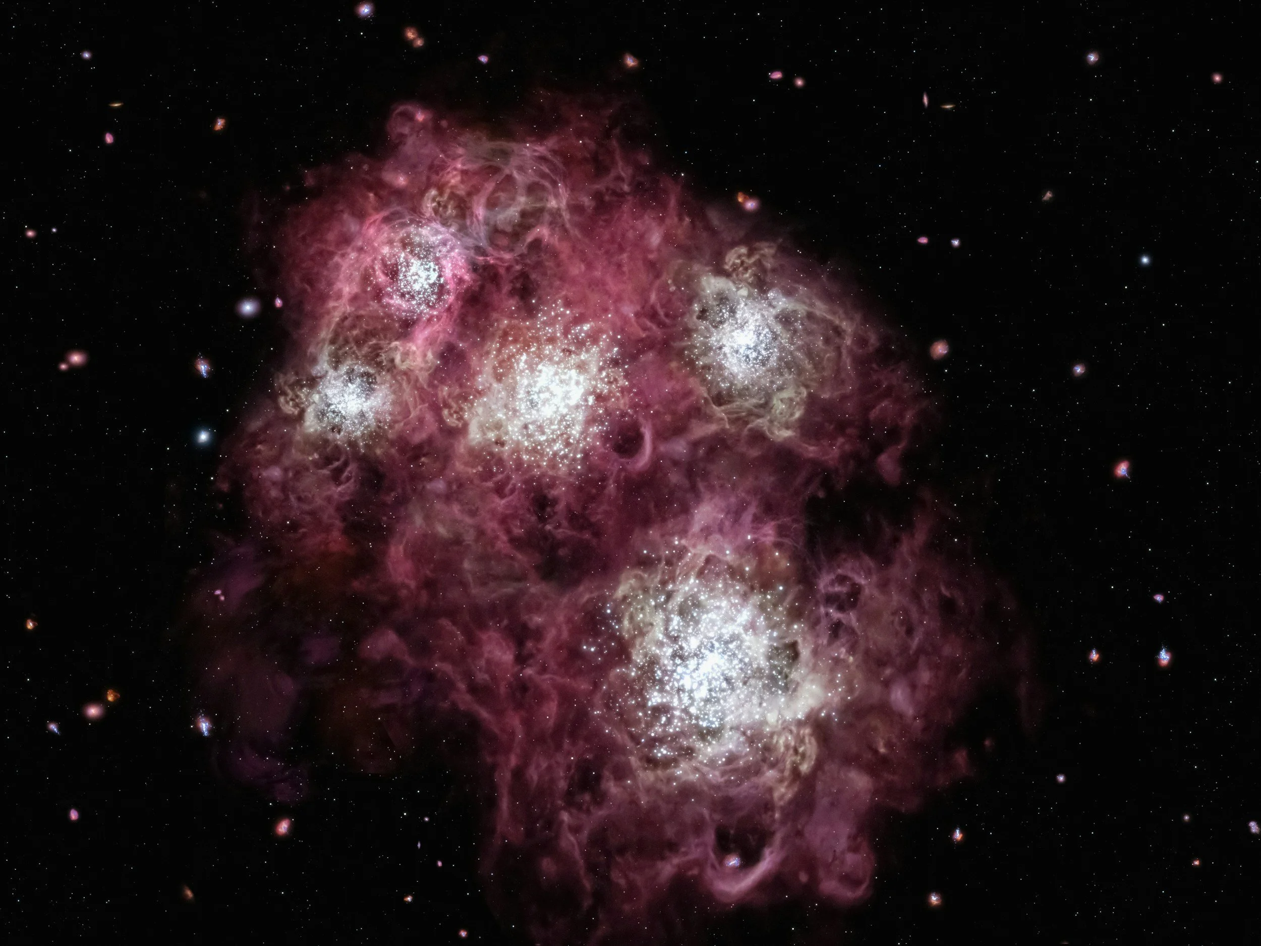 Deep space image showing a colorful nebula with bright stars and galaxy clusters surrounded by dark space.