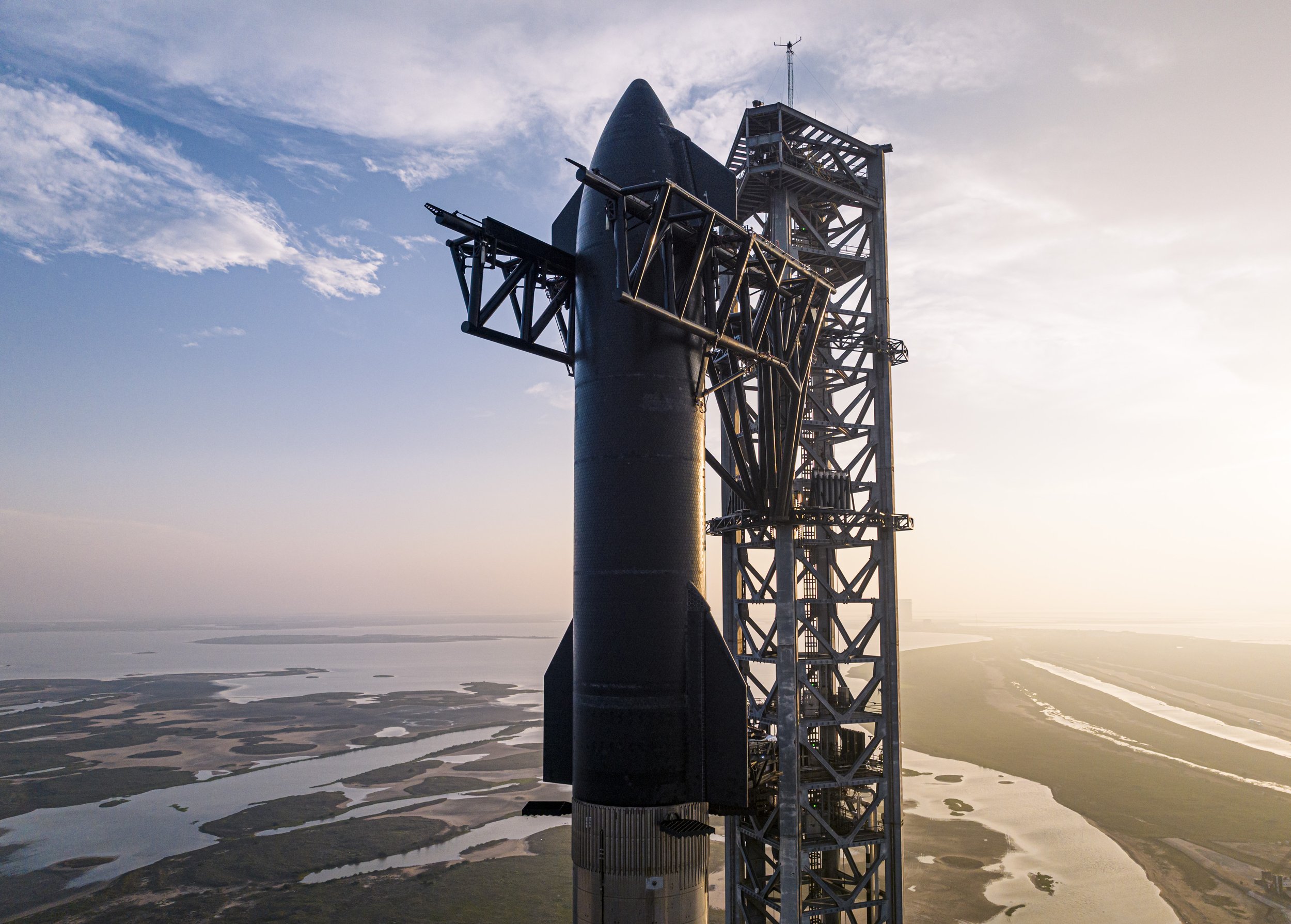 SpaceX’s Starship atop its Super Heavy booster beside the launch tower at Starbase, Texas, before its first flight test.