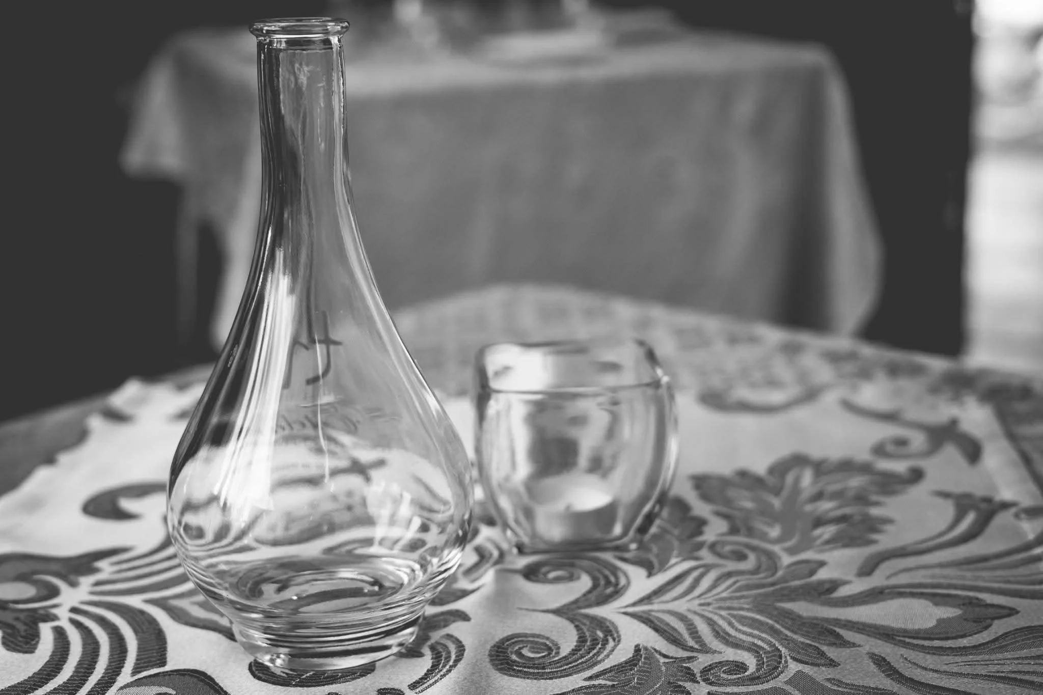 Glass carafe and candle centerpiece on patterned tablecloth at Moroccan Night event