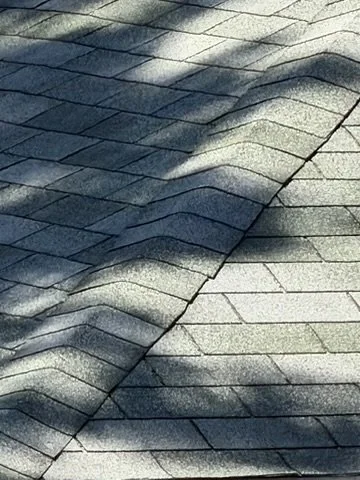 Shaded asphalt shingles roof with shadows from nearby objects