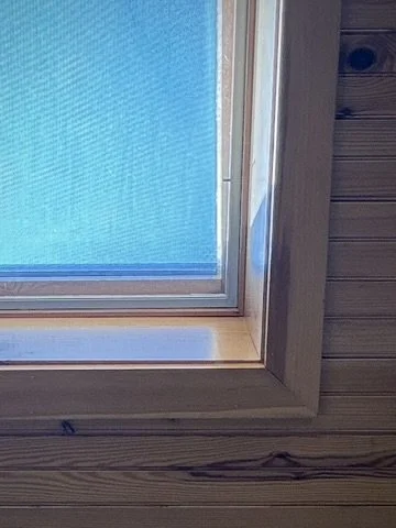 Close-up of a window with a plastic screen, showing a swimming pool outside.