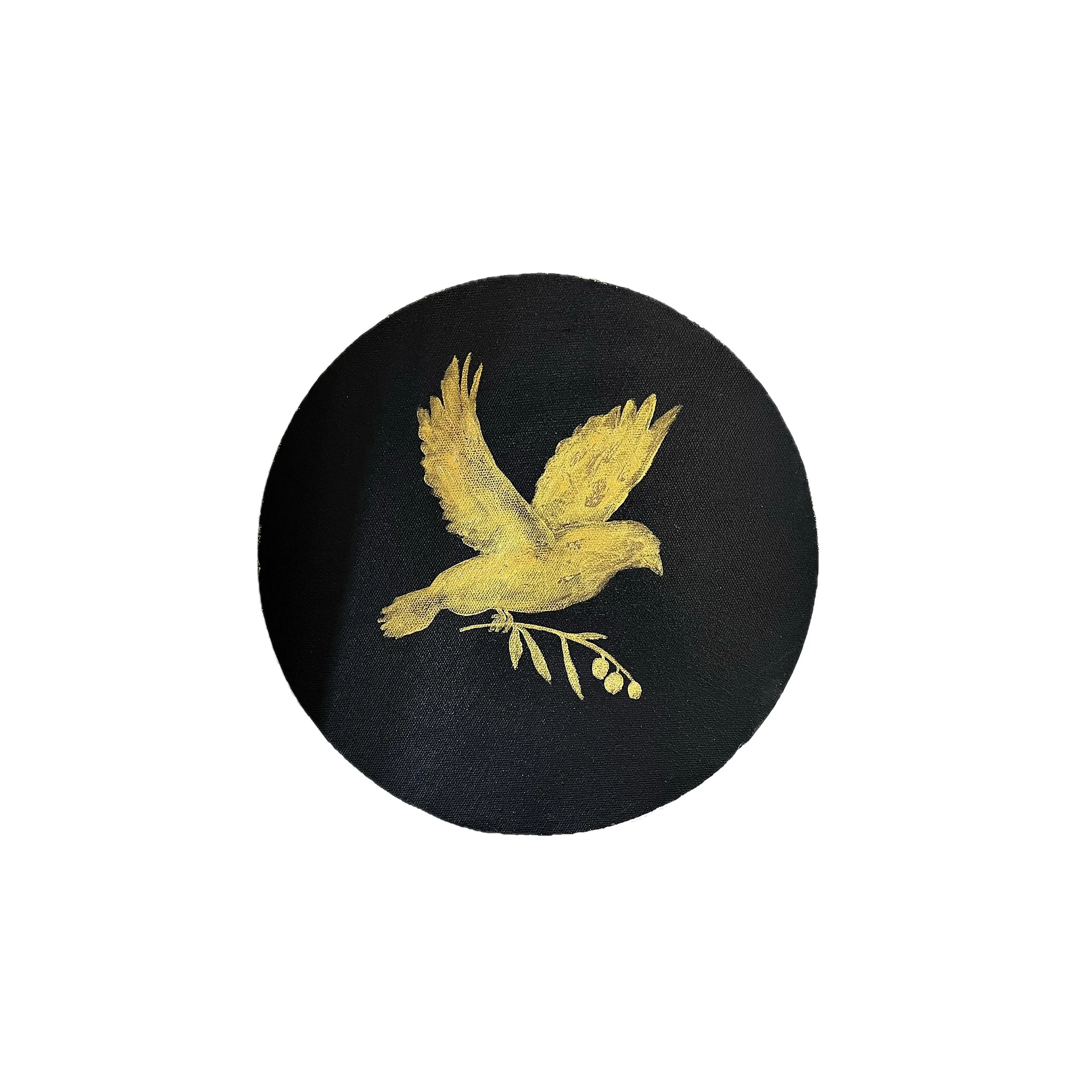 A black circular patch with a golden embroidered eagle holding a branch.