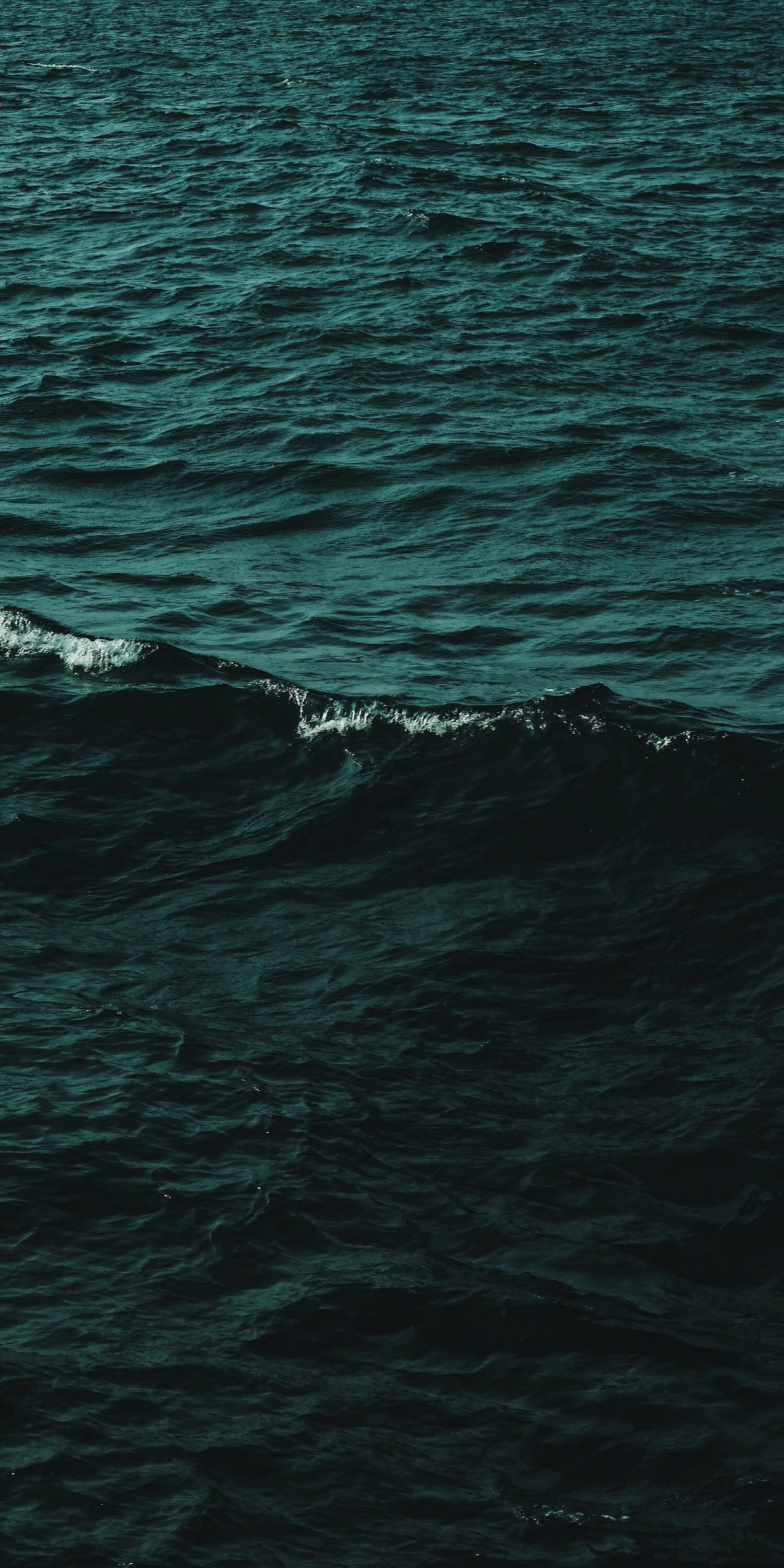 Open ocean with dark blue water and small waves.