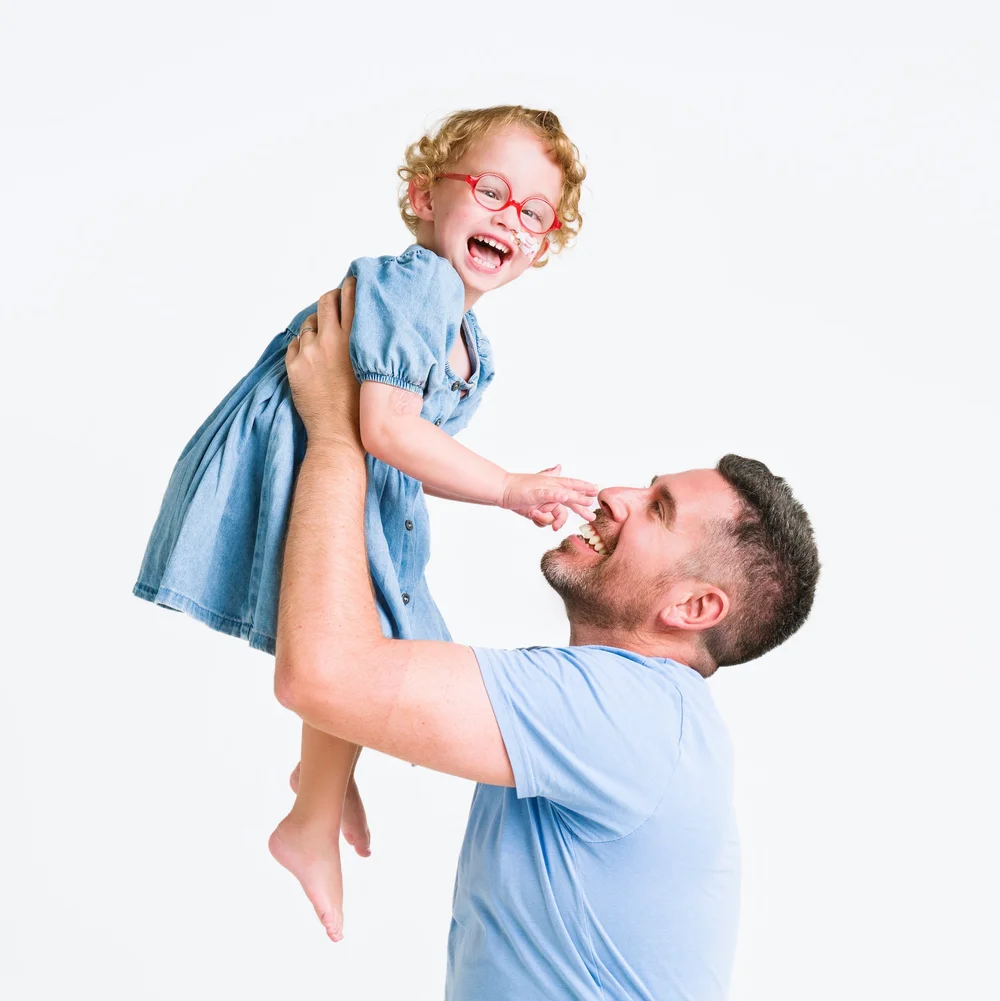Dad lifting his daughter in the air