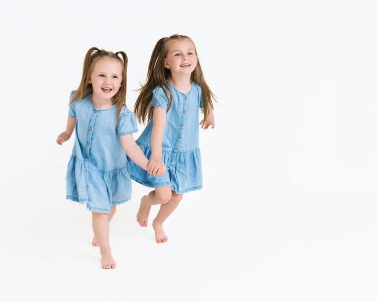 Two sisters in matching denim dresses