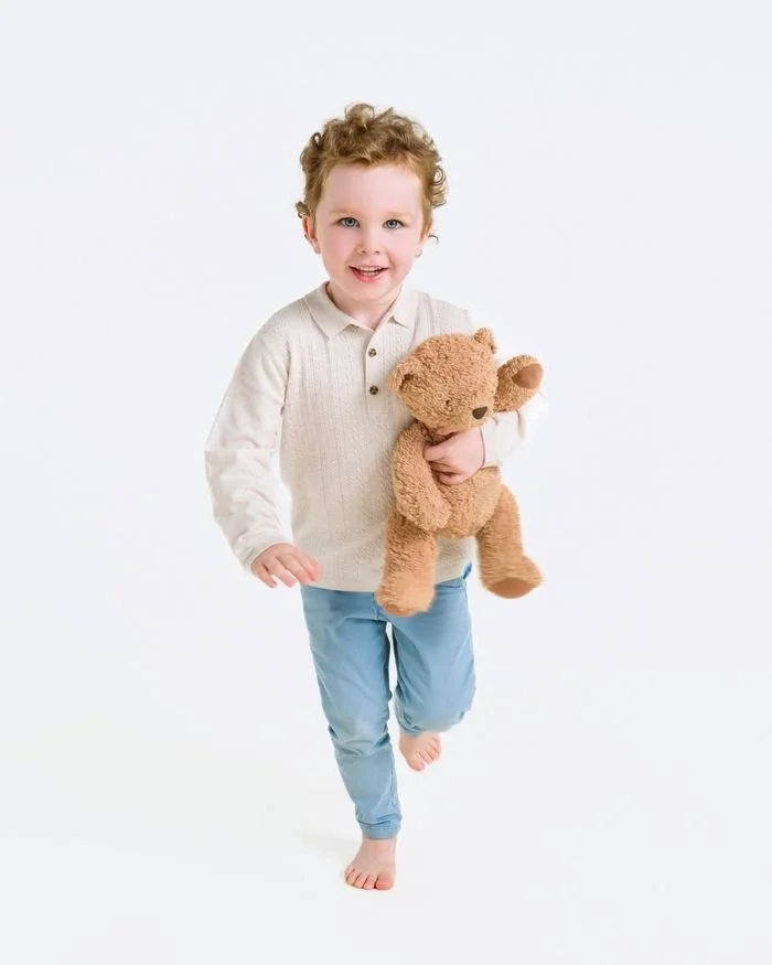 Wee boy carrying his teddy