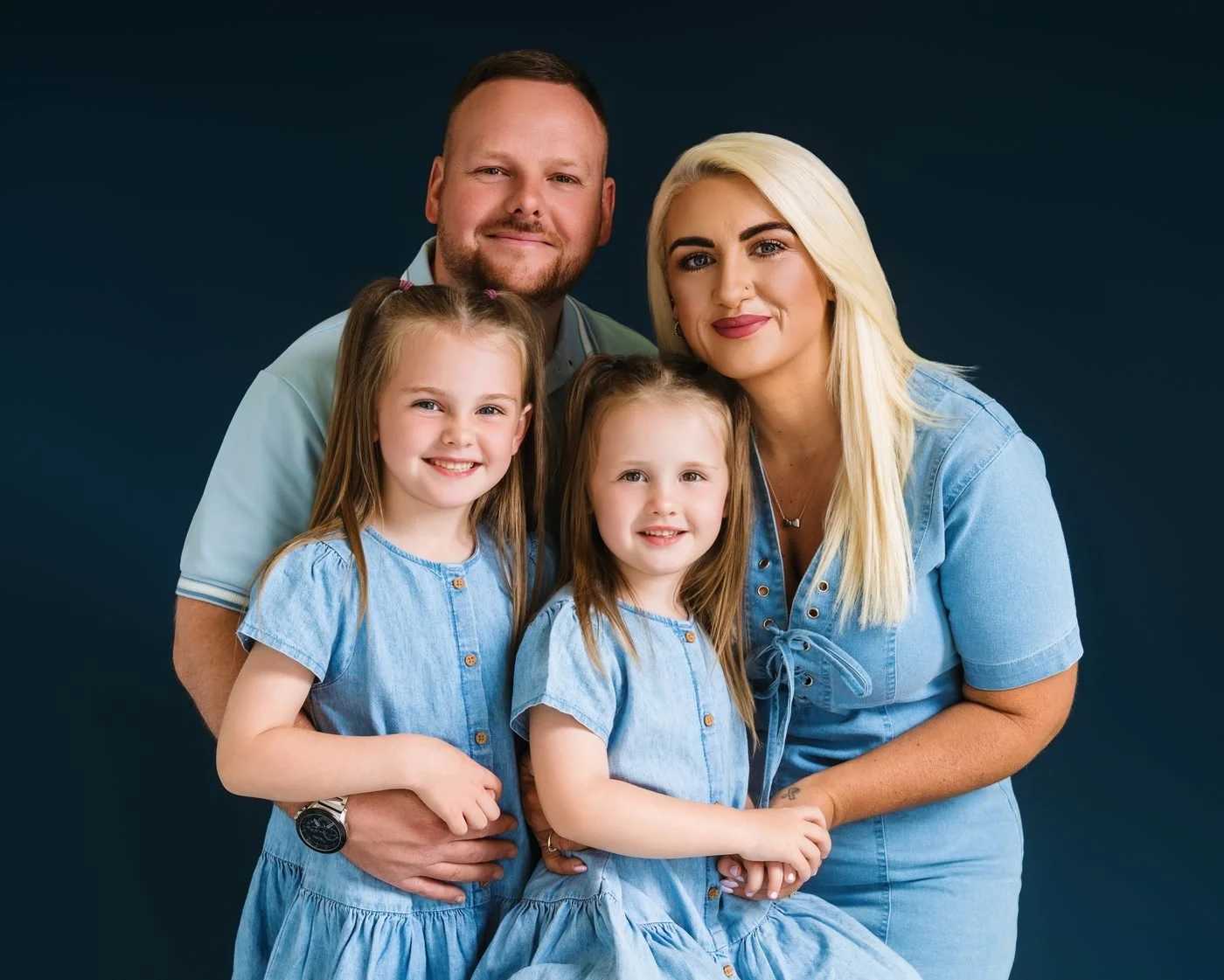 Family in shades of denim against a navy background