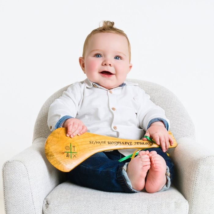 Baby holding an engraved hurl