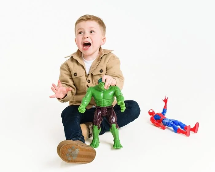 Boy playing with his superhero figures