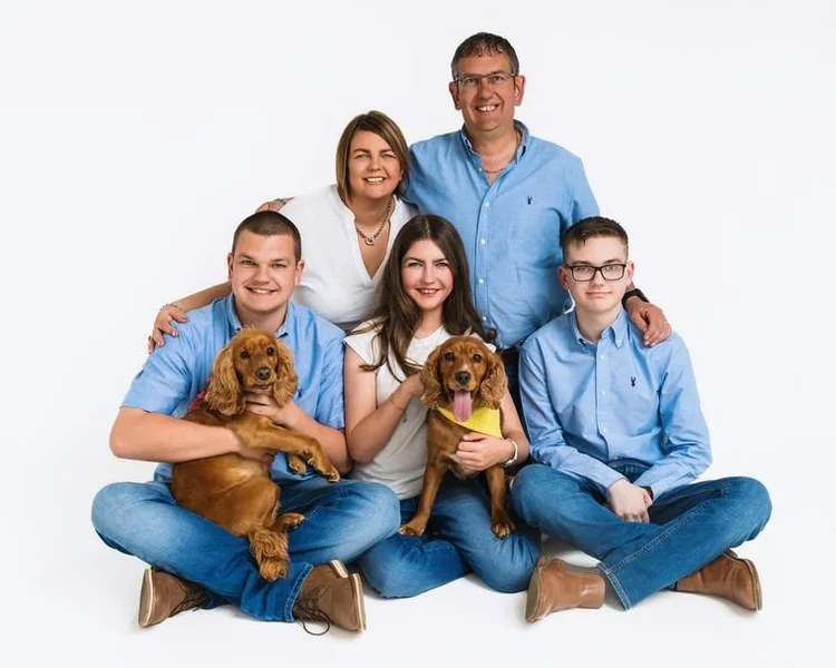 Family of five in blues with their two dogs