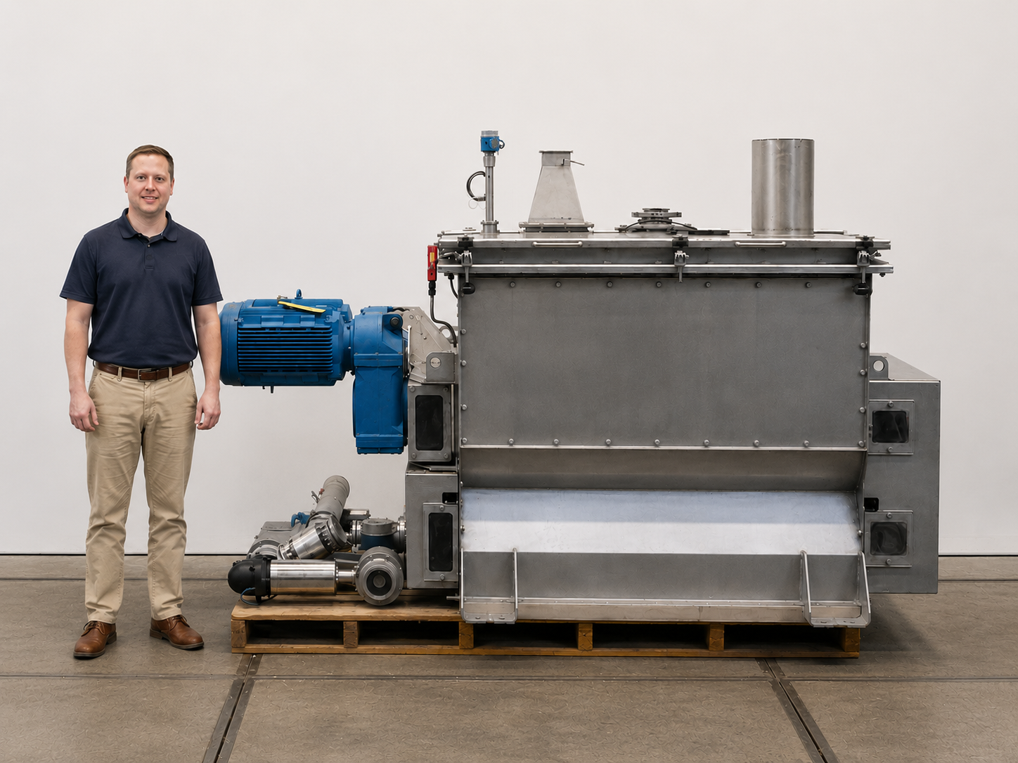A man standing next to a large industrial machine in a white room
