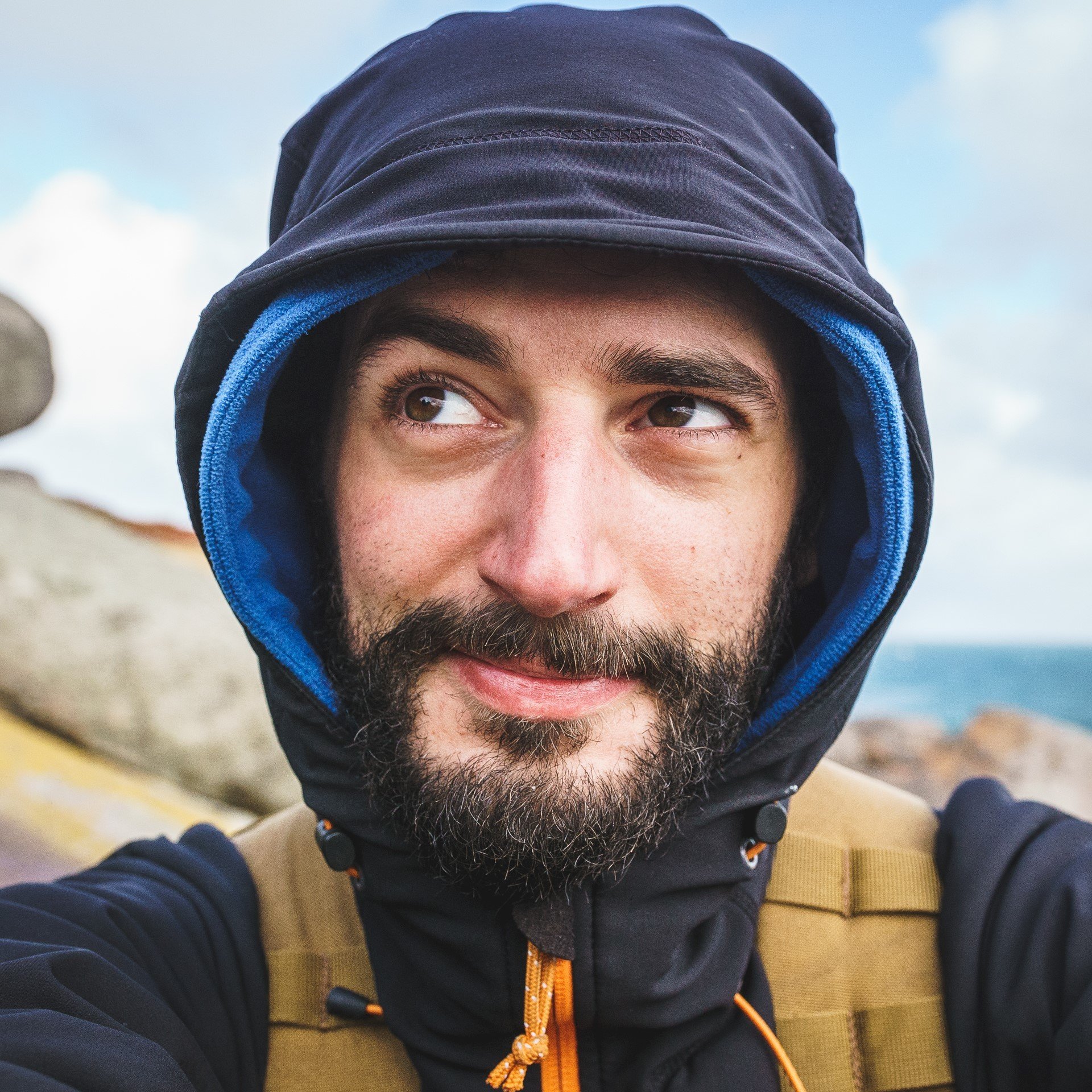 A smiling Australian bearded man in winter clothes.