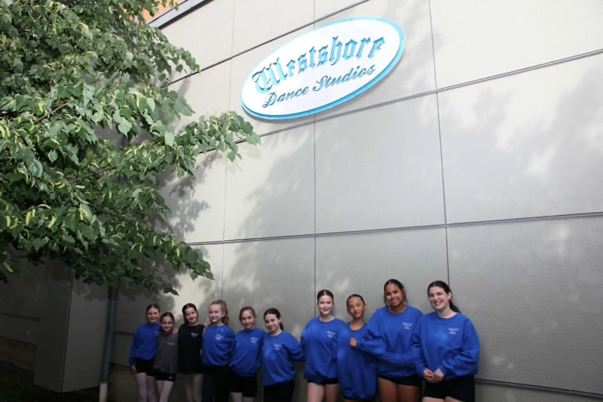 Company Smiling With Sign.jpg