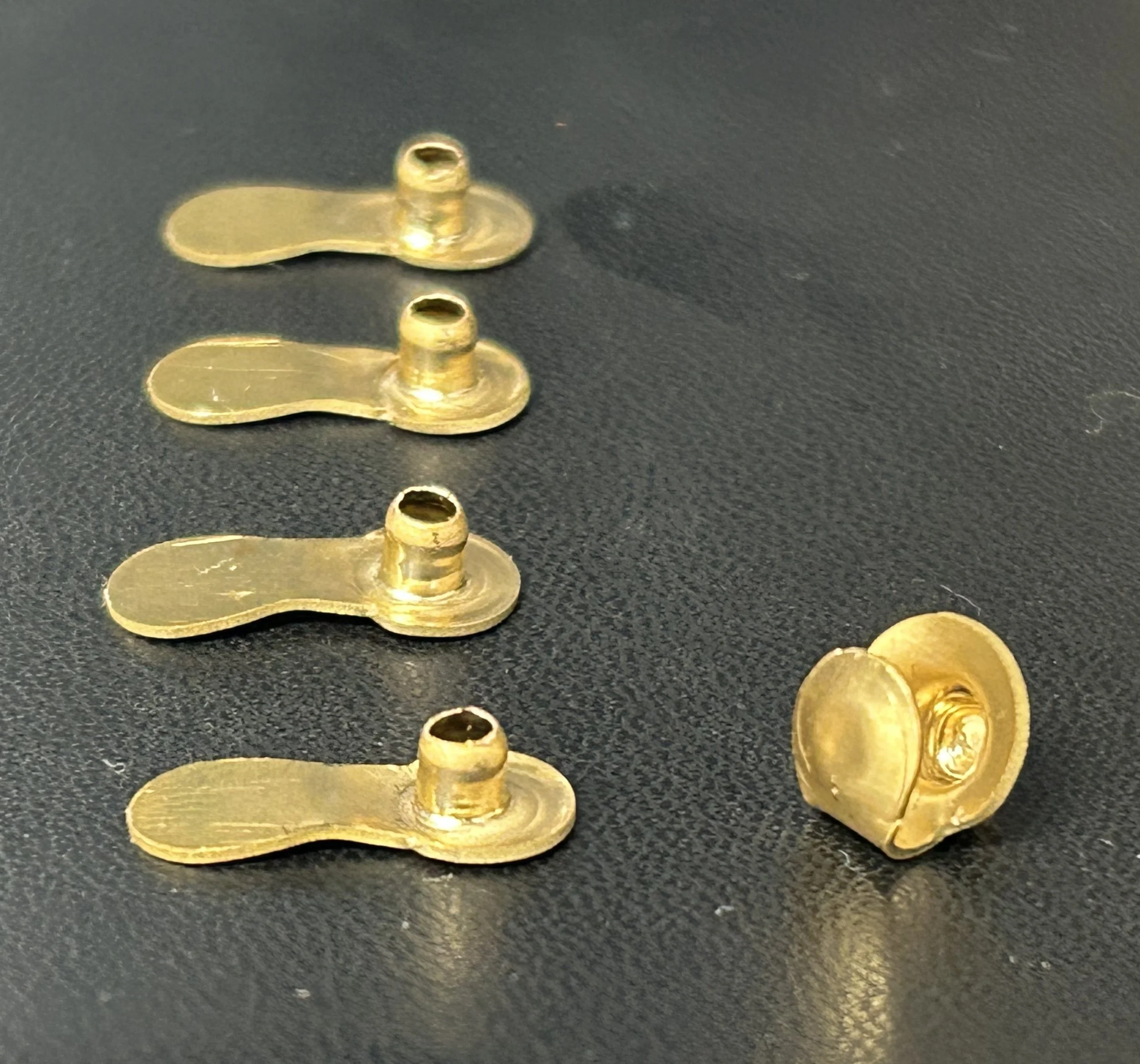 Every hook begins as a simple brass pressing before being formed into its final shape.