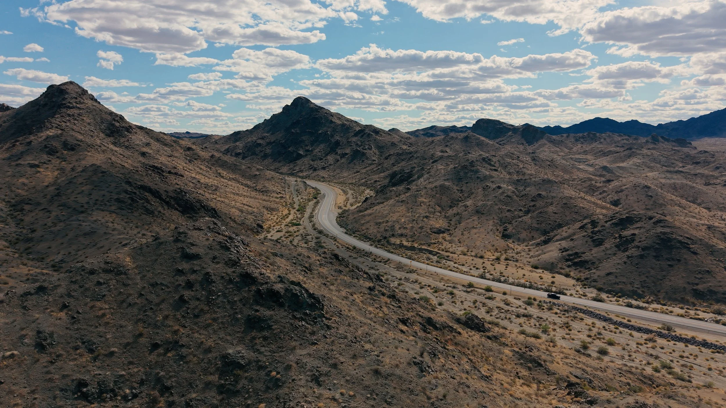 Aerial drone photography of desert terrain and roadway infrastructure.
