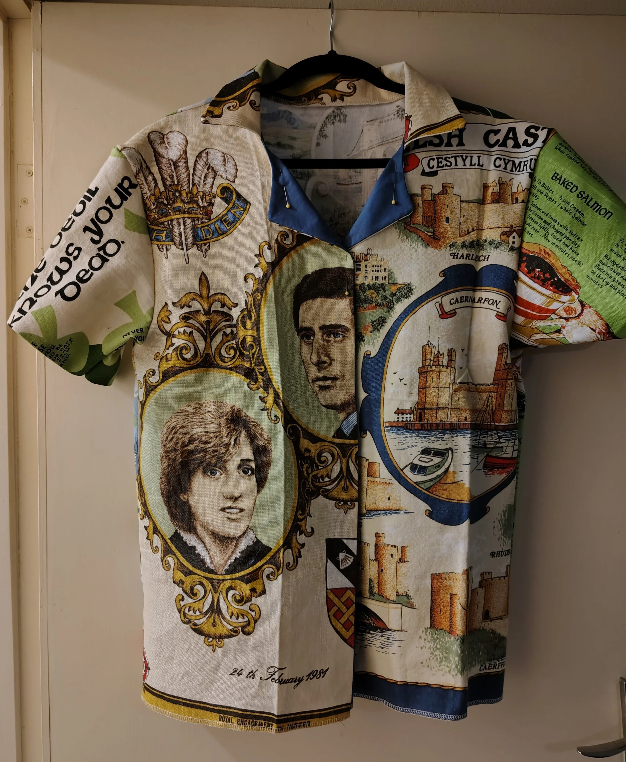 A decorative fabric covering or drape featuring iconic images, portraits, and landmarks from Wales, including a portrait of a woman, a young man, castle illustrations, and Welsh symbols, with the date '24th February 1981' at the bottom.