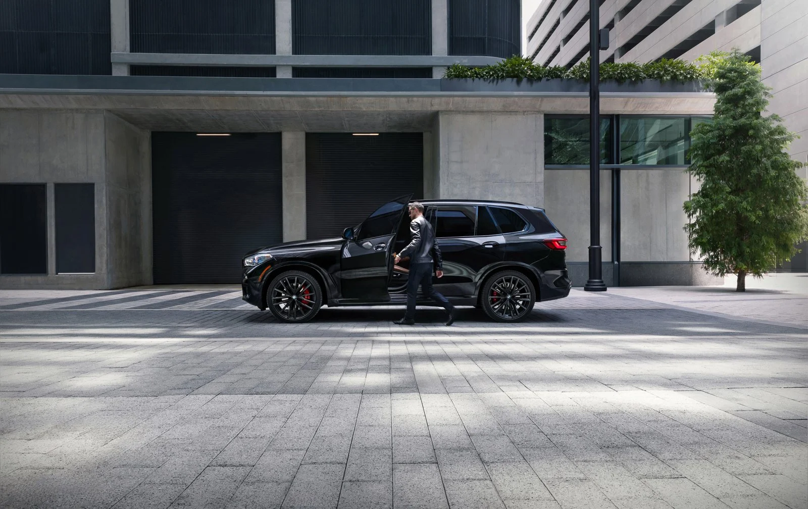 High-impact commercial advertising photography of a BMW X5 SUV in an urban city environment.
