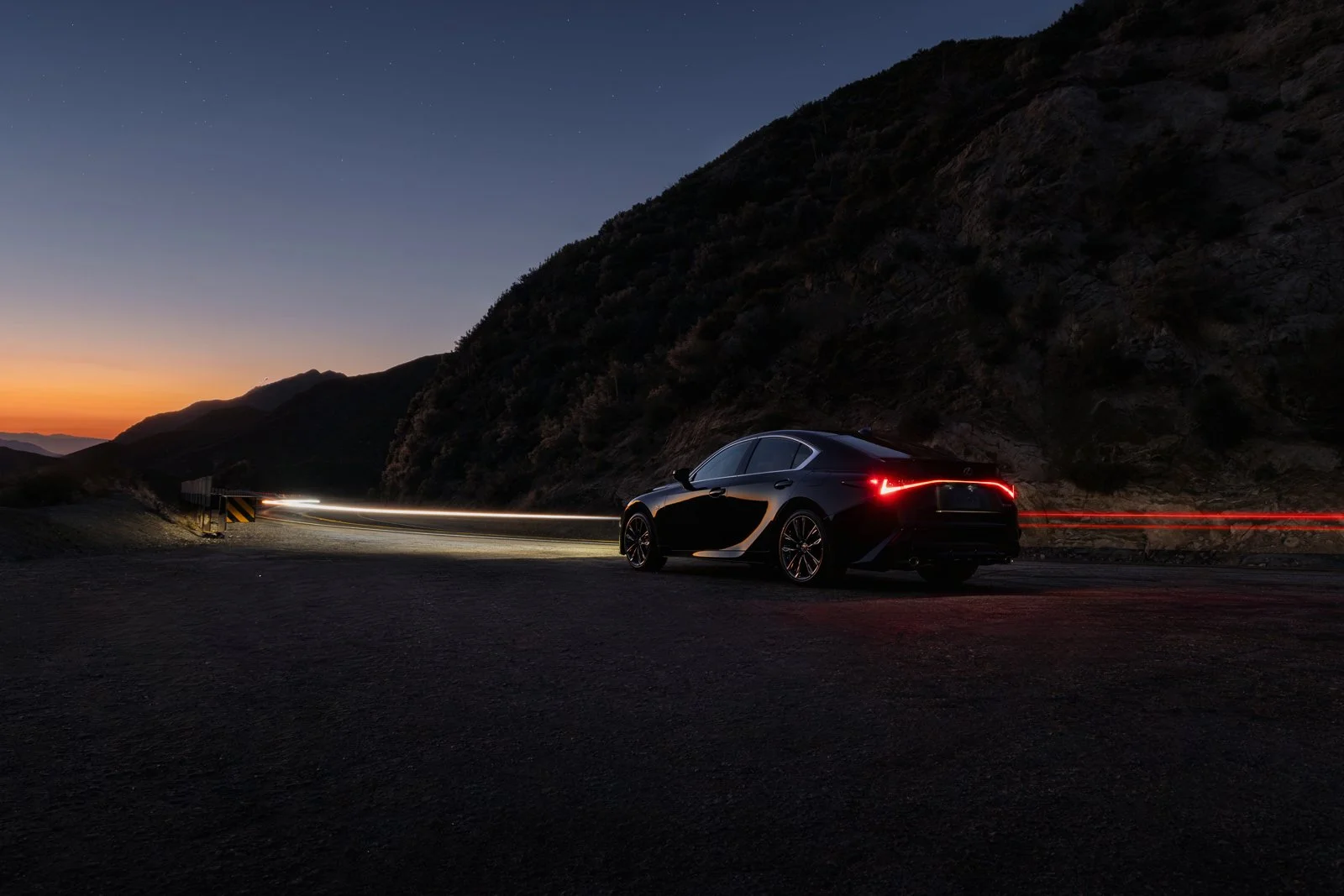 High-impact nighttime commercial advertising photography of a luxurious Lexus sedan in the mountains.