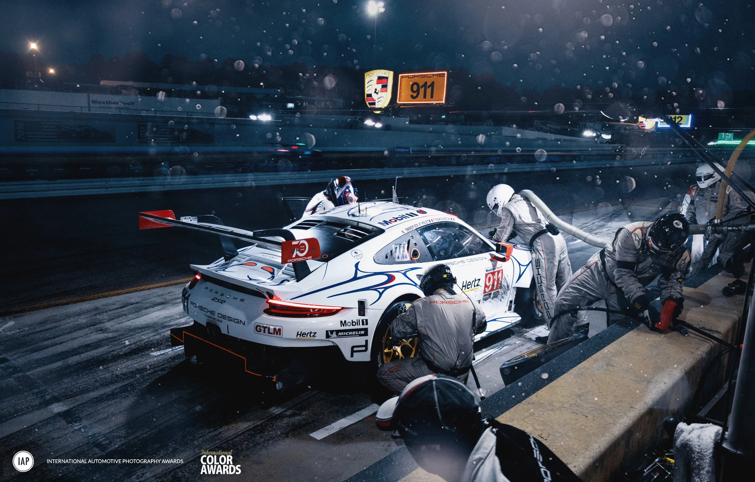 Award-winning commercial motorsport photography of a Porsche 911 RSR during an IMSA nighttime pit stop, captured by David Masemore.