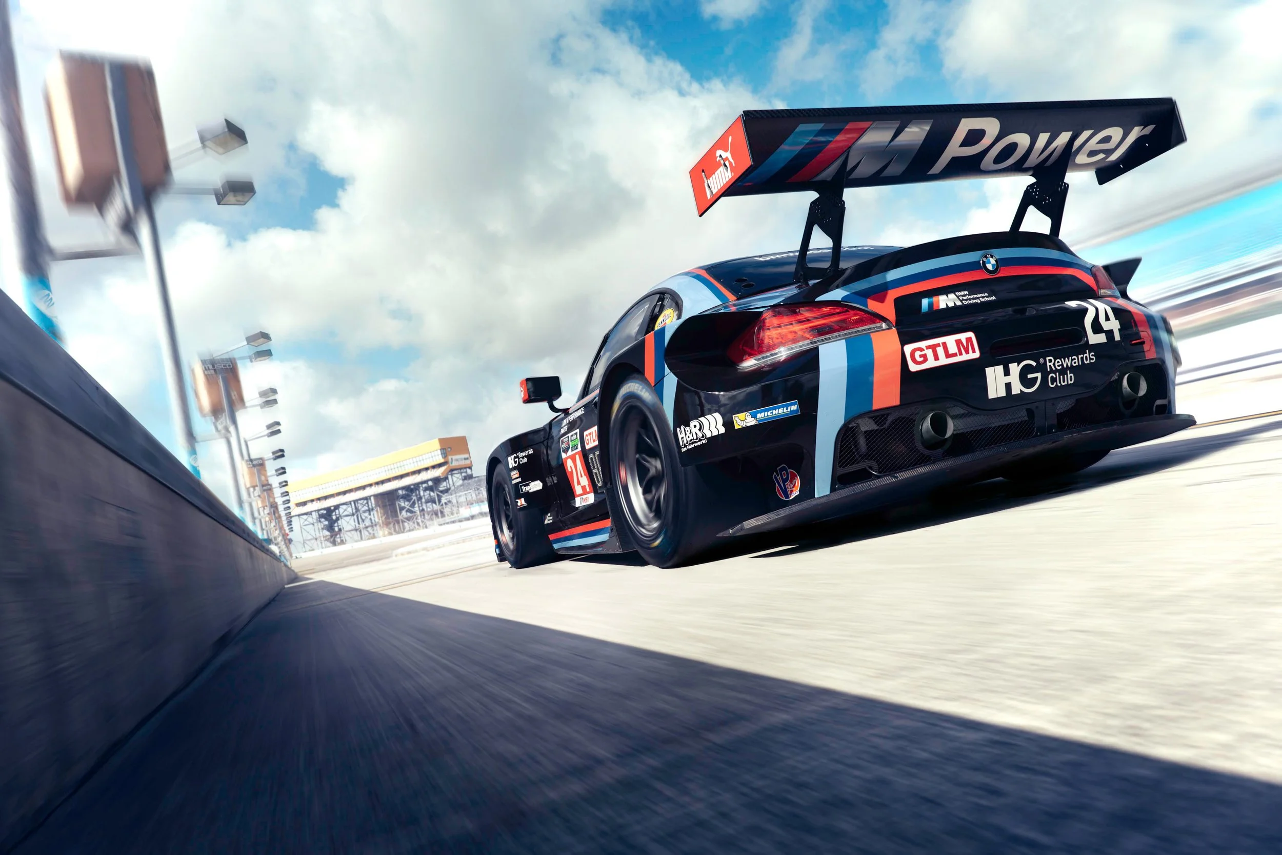 Low-angle automotive hero photograph of a BMW Z4 M race car speeding along the track during motorsport competition.