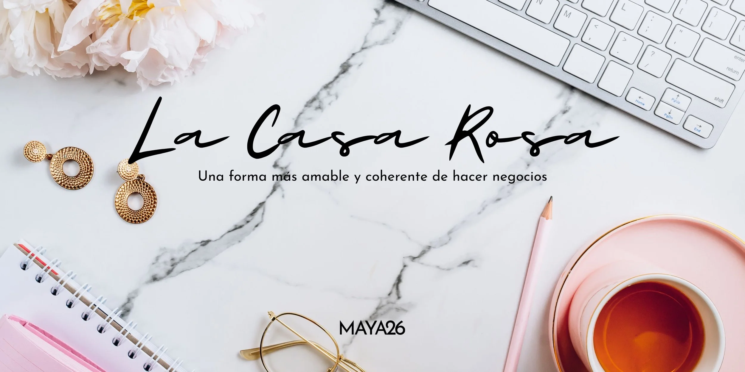 Imagen de una superficie de mármol con varios objetos de oficina y complementos: unos pendientes dorados, unas gafas, una taza de café, un cuaderno con espiral, un platito rosa y un lápiz. En el centro hay texto en letra cursiva que dice 'La Casa Rosa' y en letra más pequeña: 'Una forma más amable y coherente de hacer negocios'. Abajo, en letras capitalizadas, 'MAYA26'.