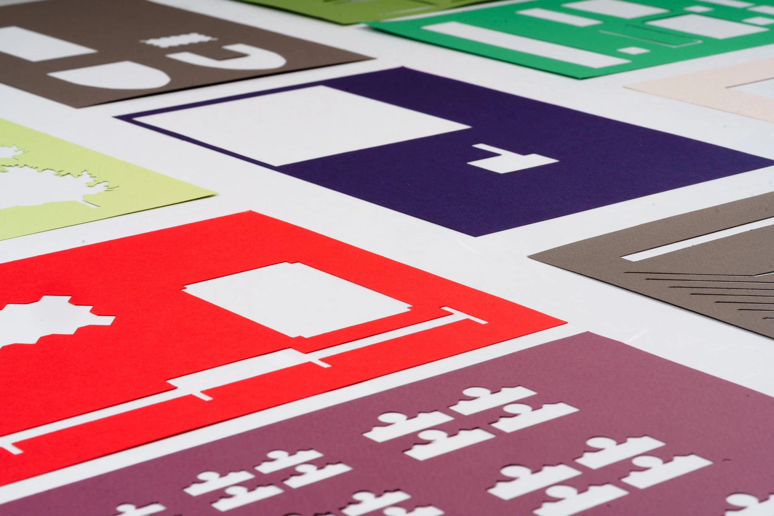 Colorful paper cutouts of various shapes and symbols spread out on a flat surface.