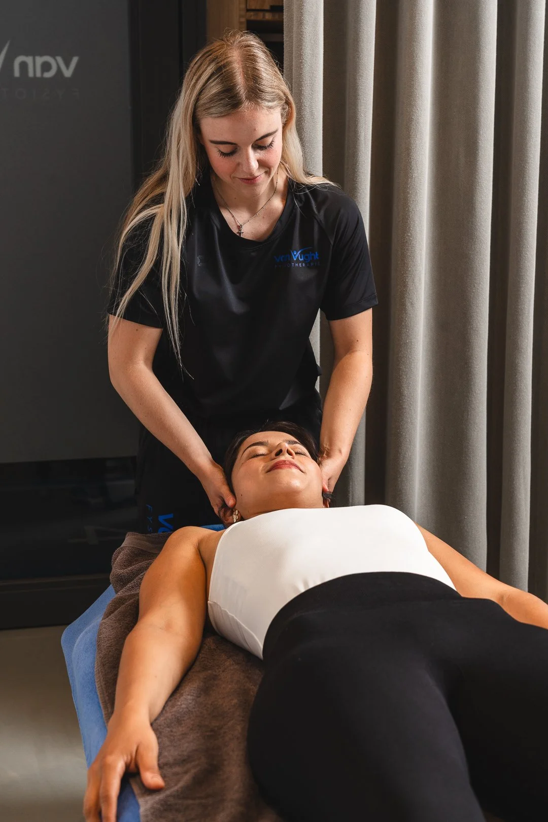 Bedrijfsfotografie van een massagetherapeut aan het werk in haar praktijk. Professionele en rustgevende beeldbank voor zakelijke dienstverleners.