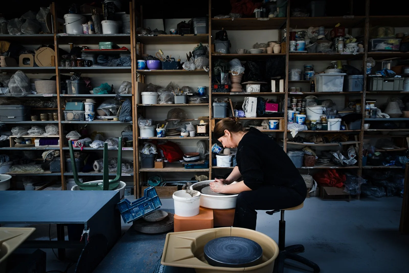 Cinematische bedrijfsreportage van een maker aan het werk in een ruim keramiek atelier. Authentieke fotografie van creatief ambacht.