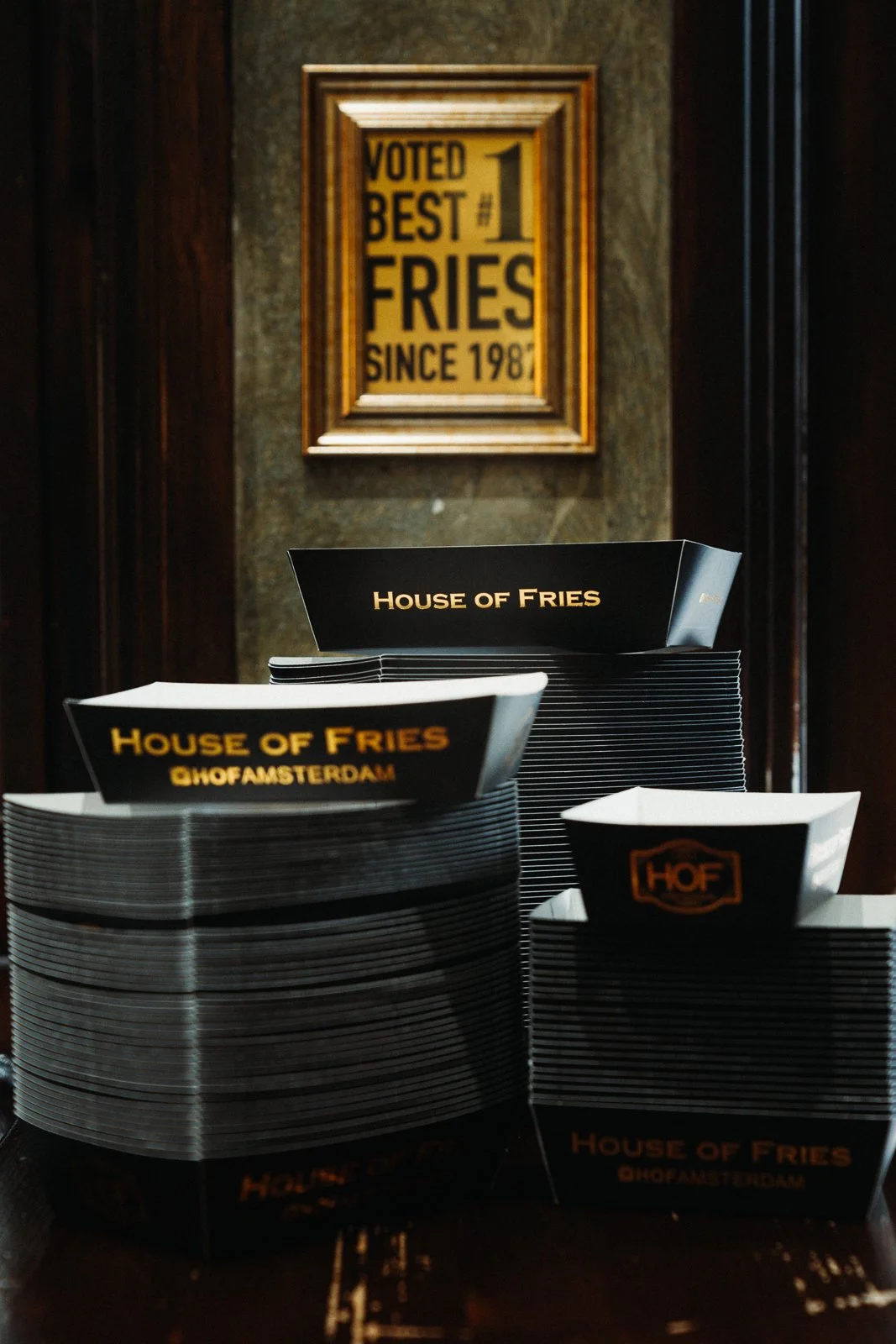 Moody detailfotografie van gestapeld donker servies in een chique horeca setting. Sfeervol beeldmateriaal voor culinaire ondernemingen.