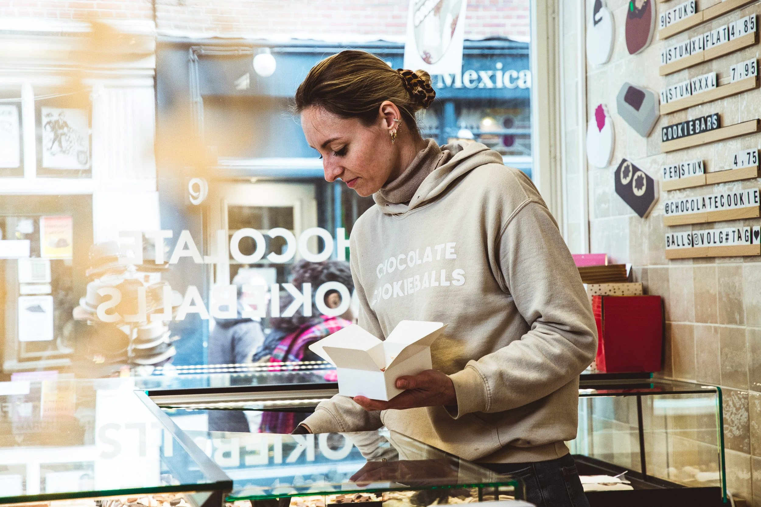 Sfeervolle fotografie van een vrouwelijke onderneemster in haar winkel of boetiek. Personal branding shoot voor creatieve ondernemers.
